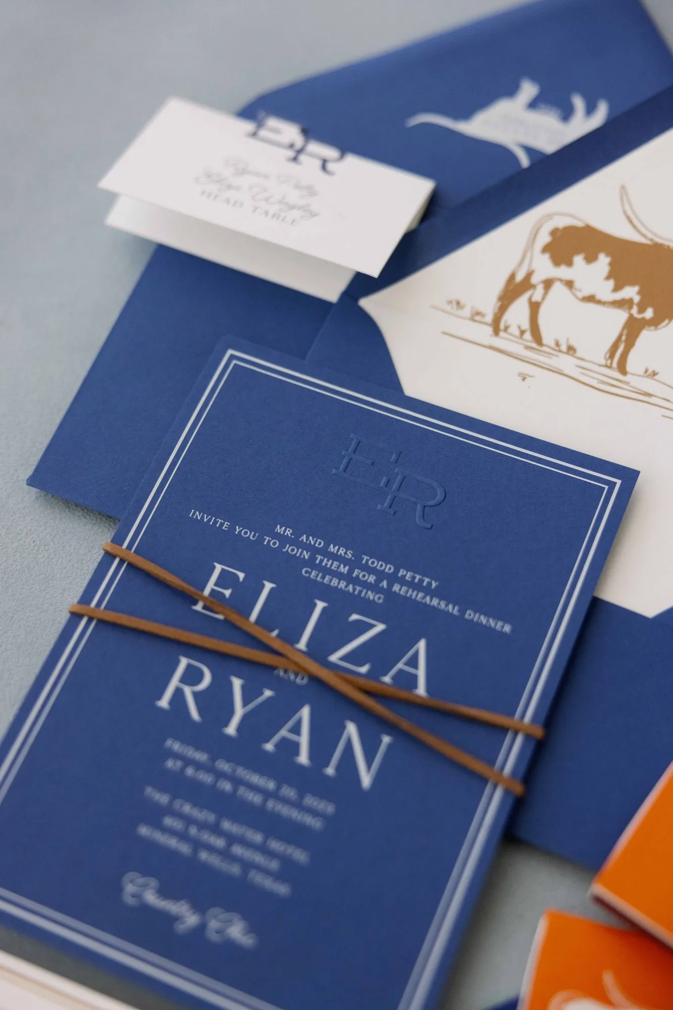 Navy Eliza envelope with a white longhorn on the flap, opened to a gold longhorn liner